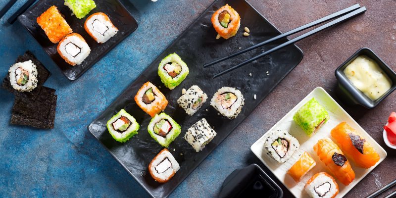 japanese-food-sushi-rolls-chopsticks-soy-sauce-stone-background